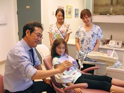 診療室で、歯の模型を使って説明している様子
